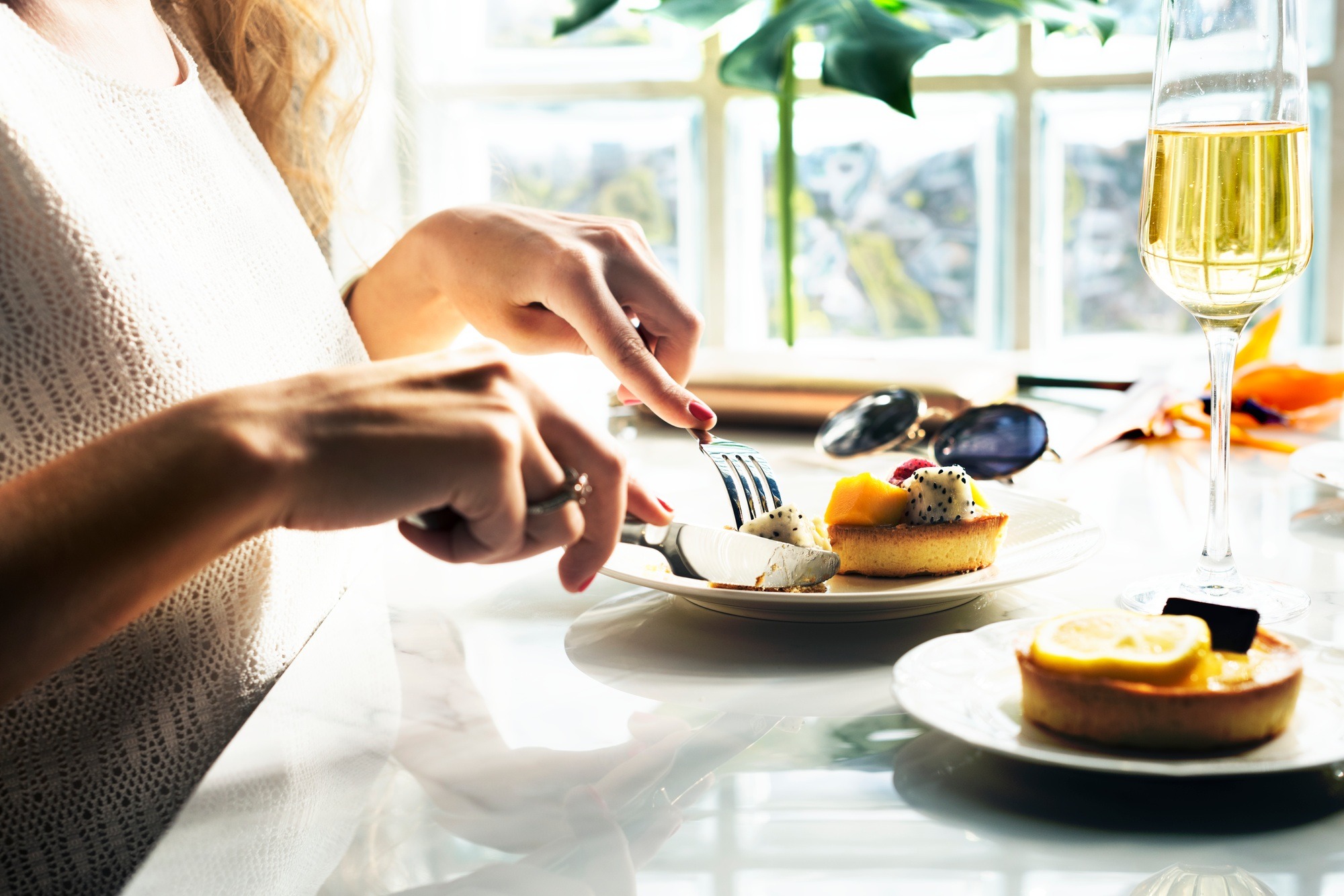 Woman is eating pastry at the restaurant