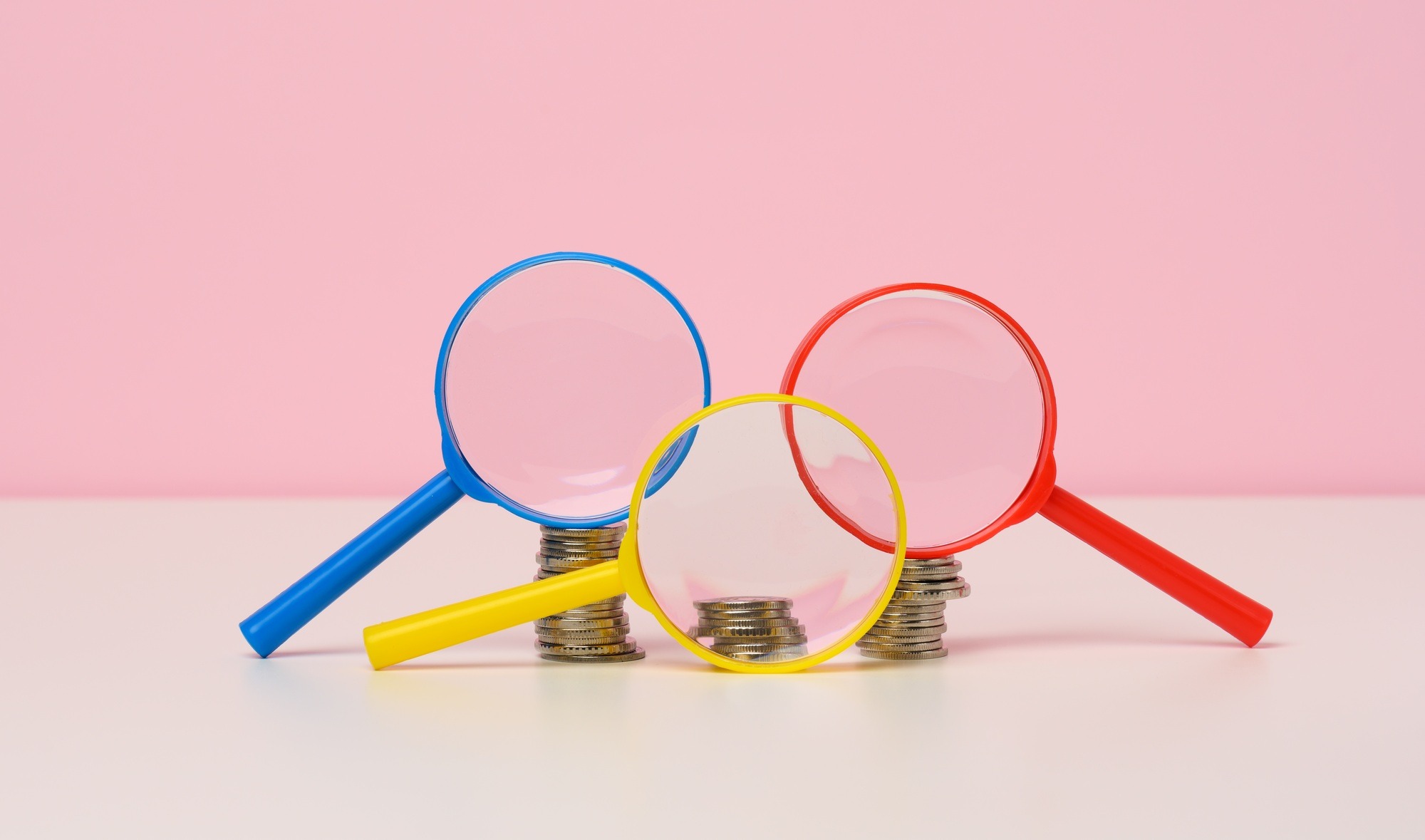 Magnifier and white coins on the table. Income growth concept