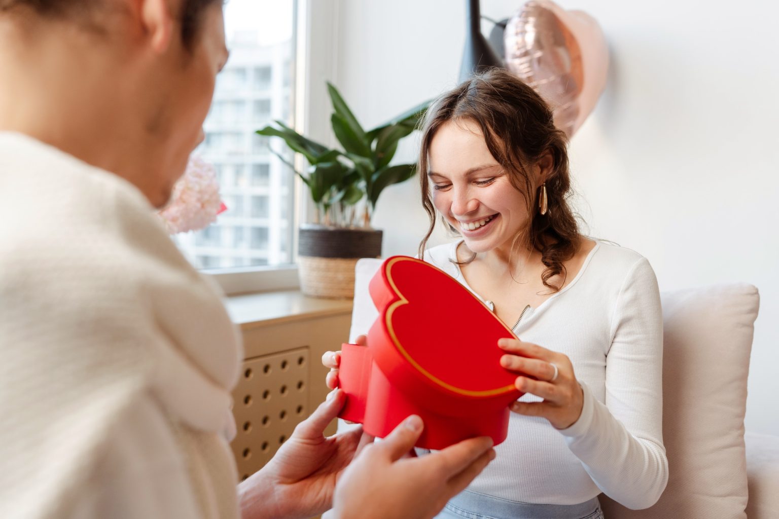 Woman opening gift box. Happy romantic couple celebration birthday. Dating, love, Valentines day