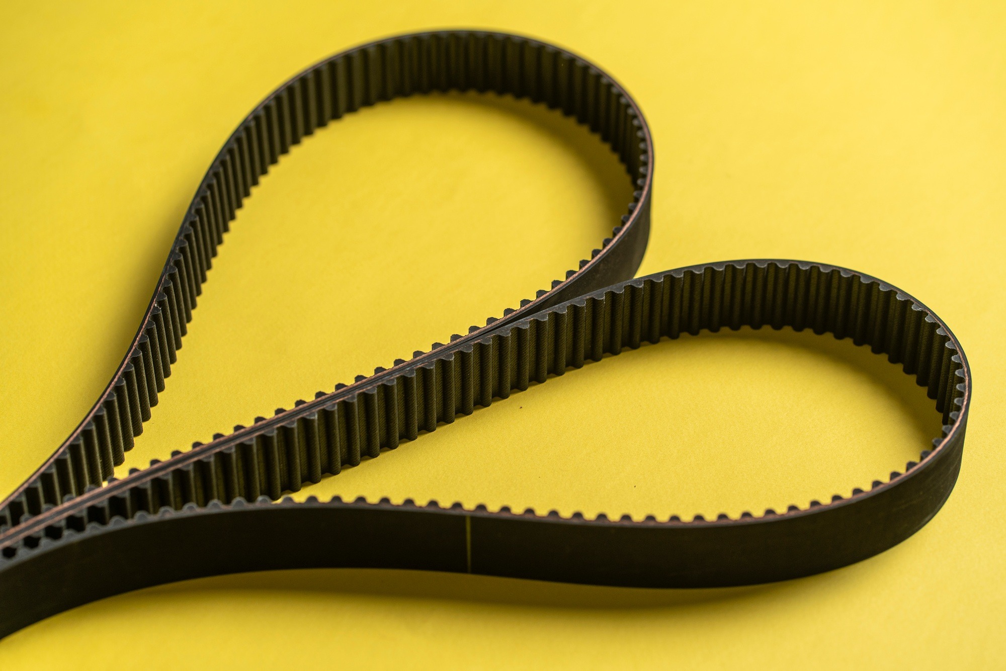 a new spare parts for car repair, black engine timing belt on the table