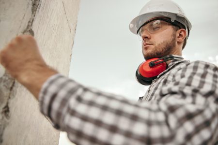 Construction worker installing concrete column