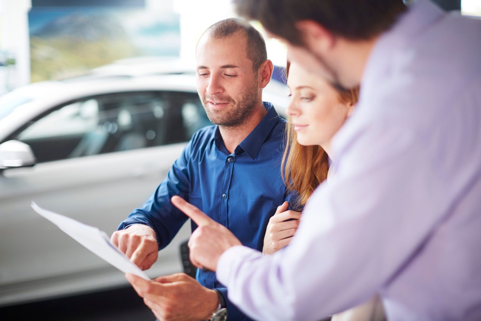 Couple at car dealer buying new car