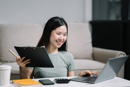 lifestyle of office workers Woman calculating expenses and using laptop.