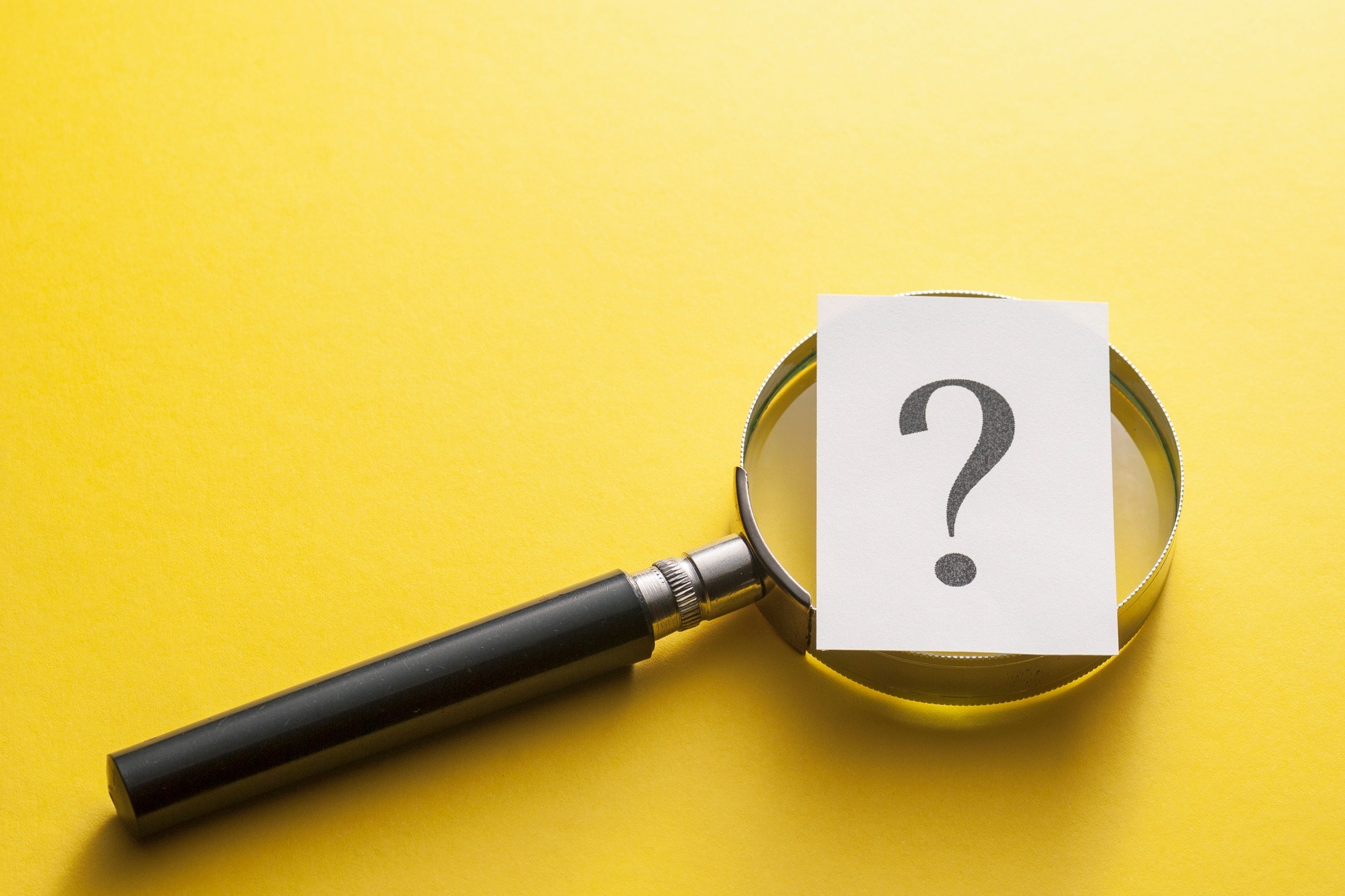 Magnifying glass with question mark on yellow