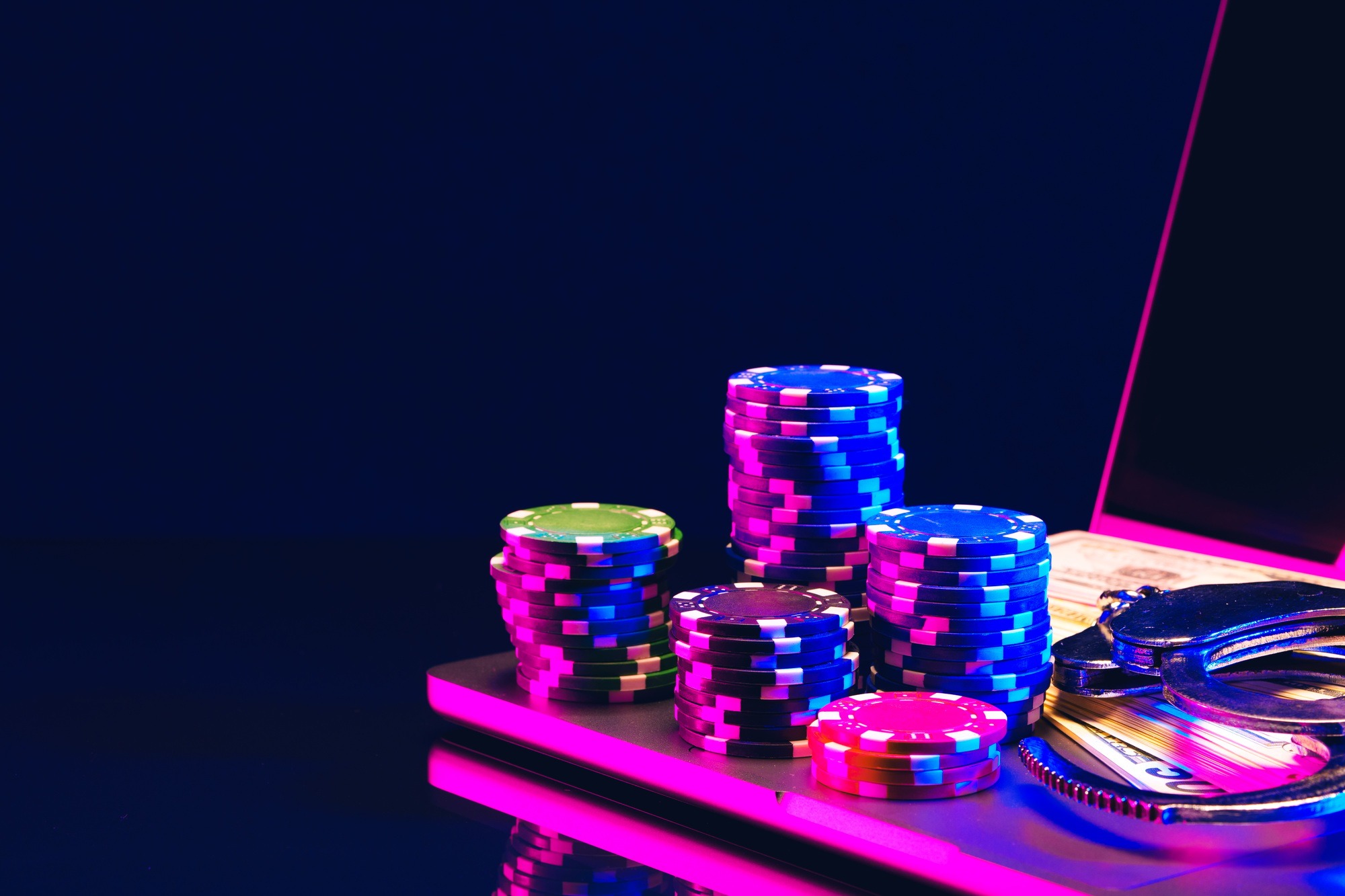 Stacks of Casino Chips and Handcuffs on Laptop Keyboard