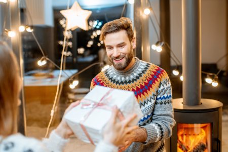Couple celebrating winter holidays with gifts at home