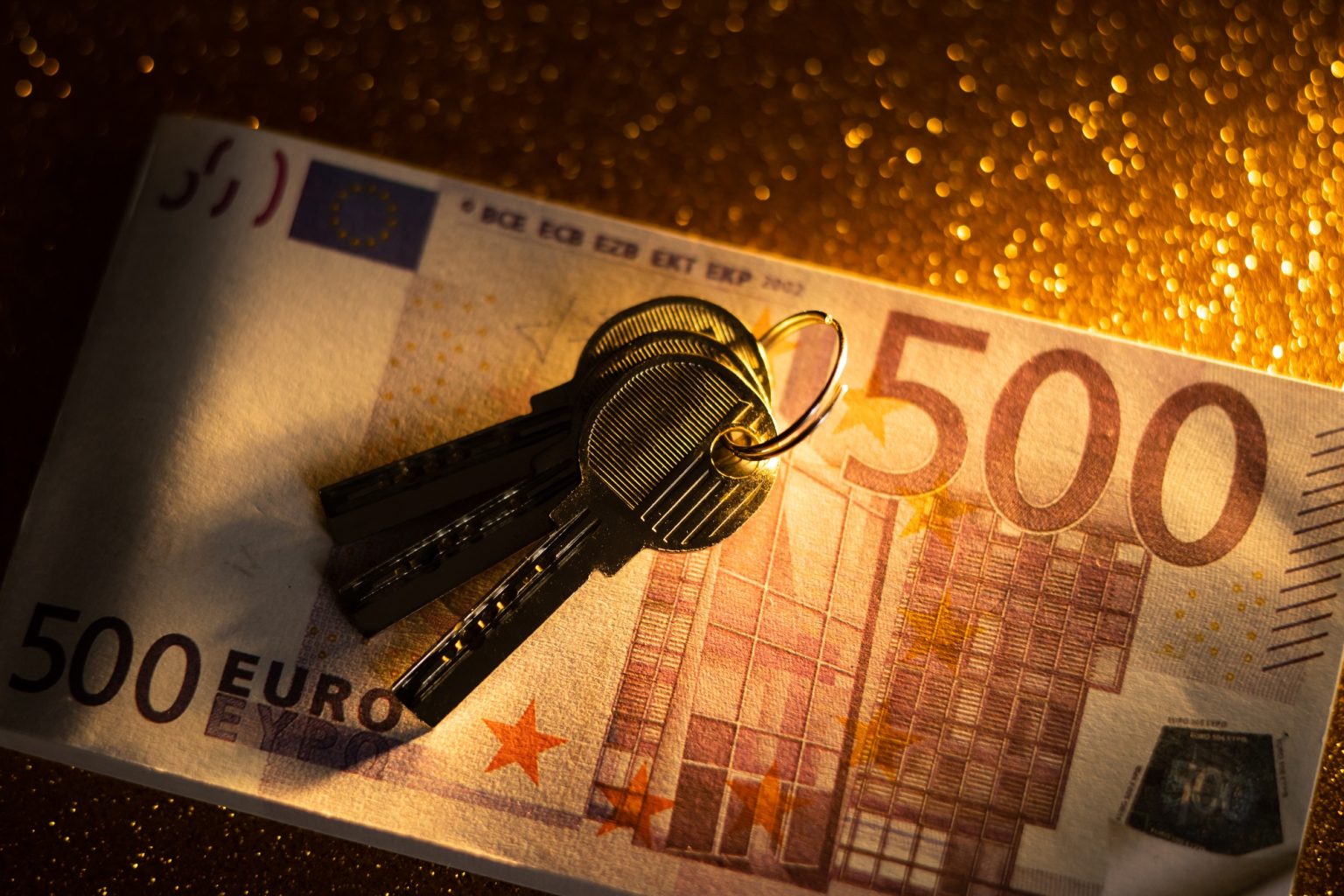 keys and money banknotes on golden background