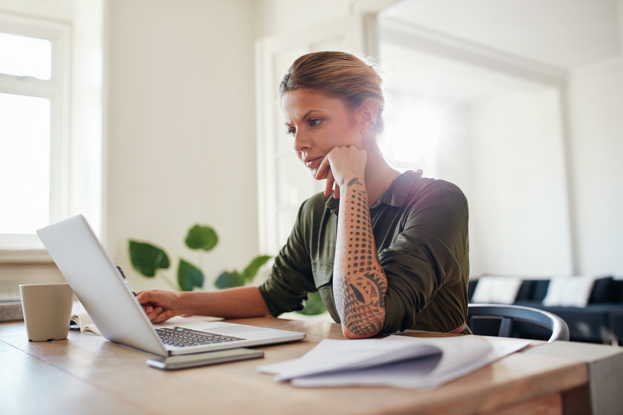 Young woman looking at laptop seriously.