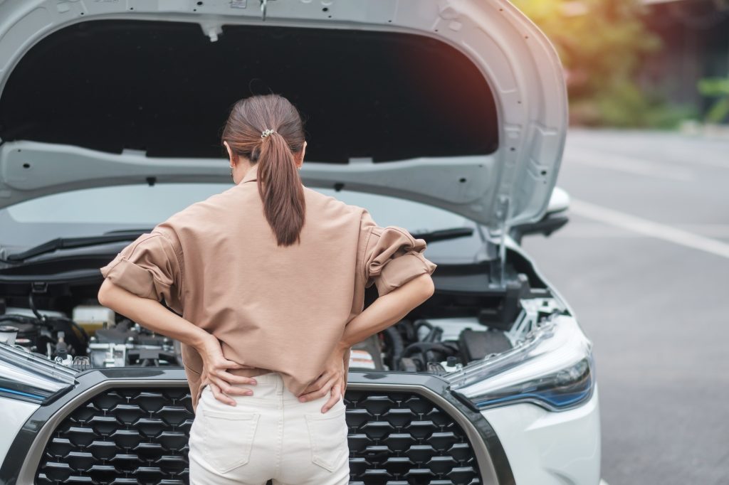 woman driver standing near a problem car. Breakdown or broken car on road. Vehicle Insurance, mainte