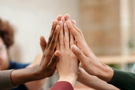 Close-up of diverse group hands high-fiving symbolizing teamwork and unity.