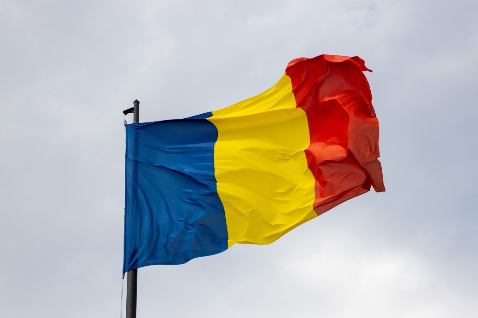 National flag of Romania waving against a cloudy sky
