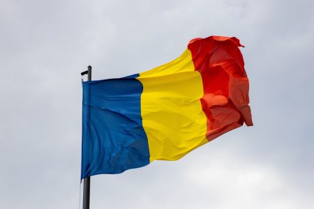 National flag of Romania waving against a cloudy sky