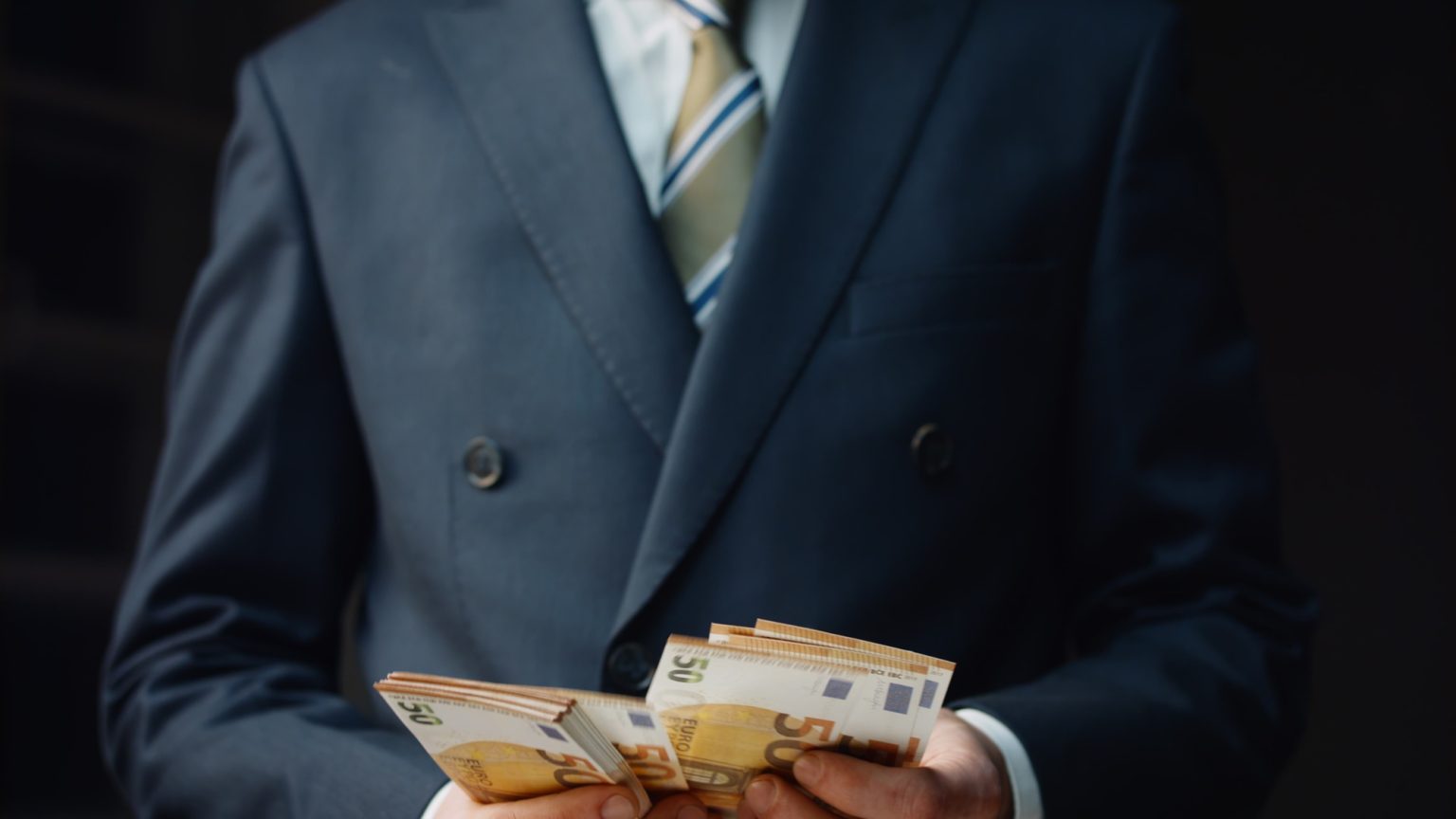 Successful financier counting salary in euro close up. Man calculating banknotes