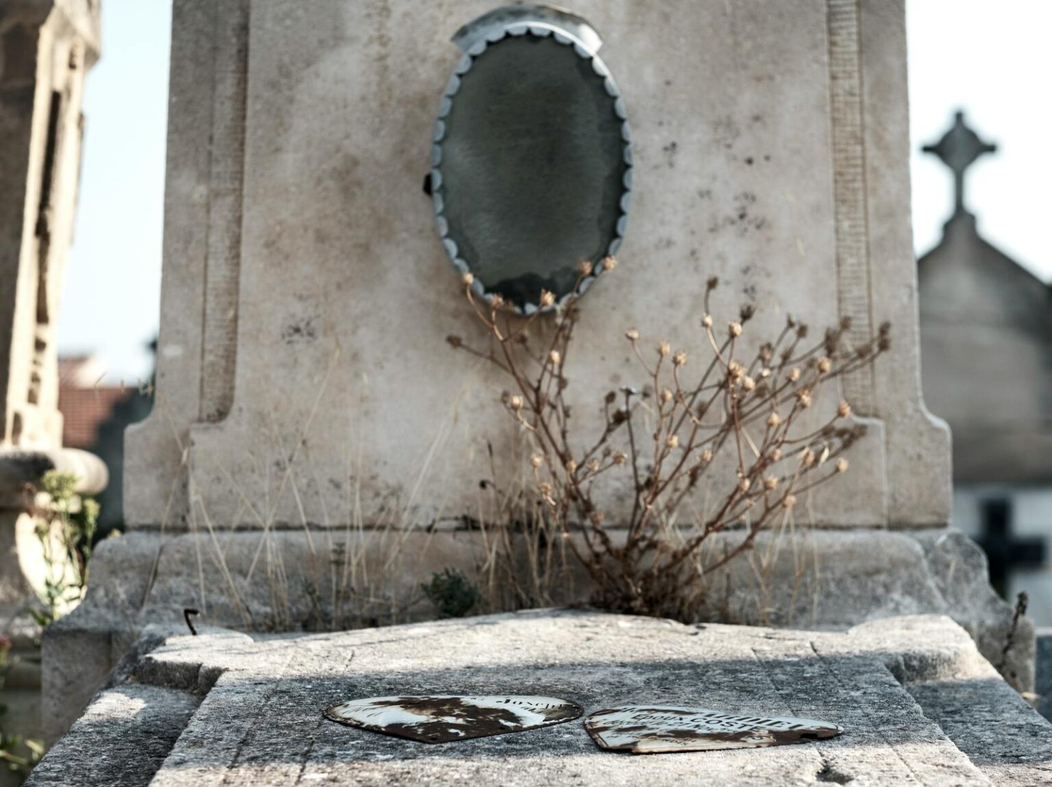 A close-up of a weathered tombstone in Arles Cemetery, capturing the essence of history and decay.