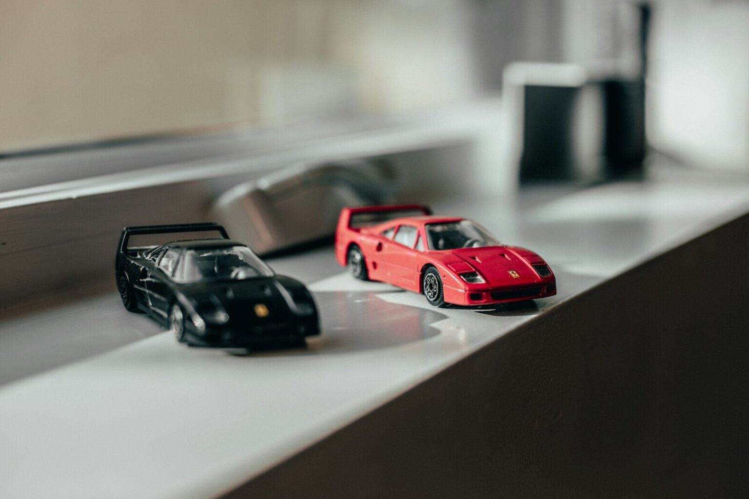 two black and red sprots car toys near windwo