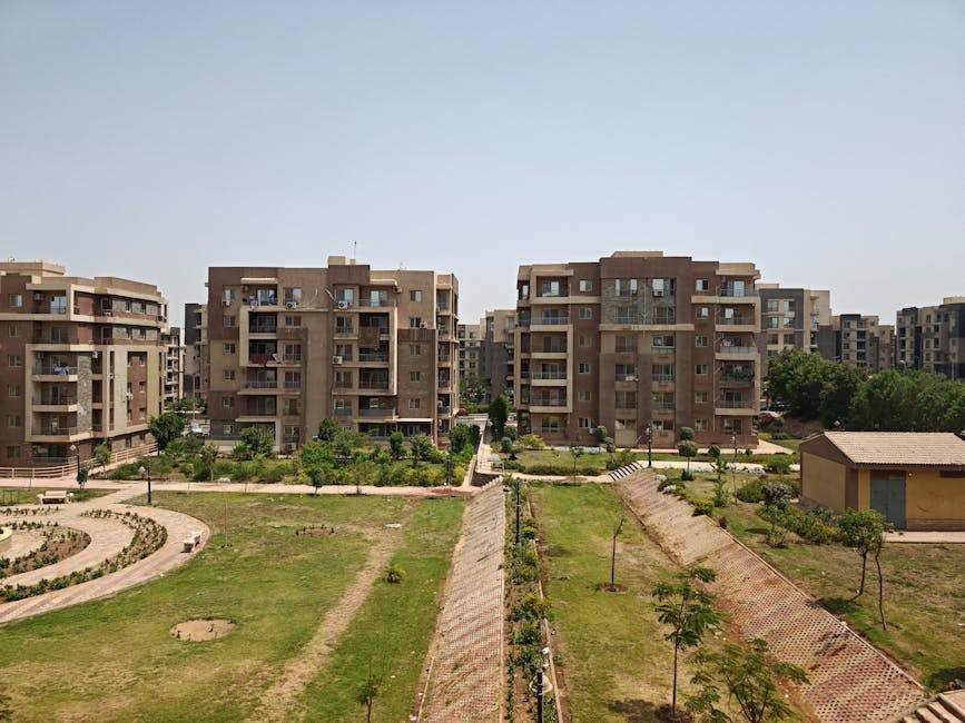 Taux de crédit immobilier : comment la guerre en Iran rebattre les cartes en France Aerial view of modern apartment buildings surrounded by lush greenery on a sunny day.