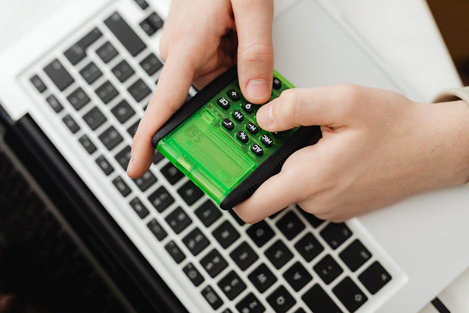 Person comparing insurance offers on laptop with calculator