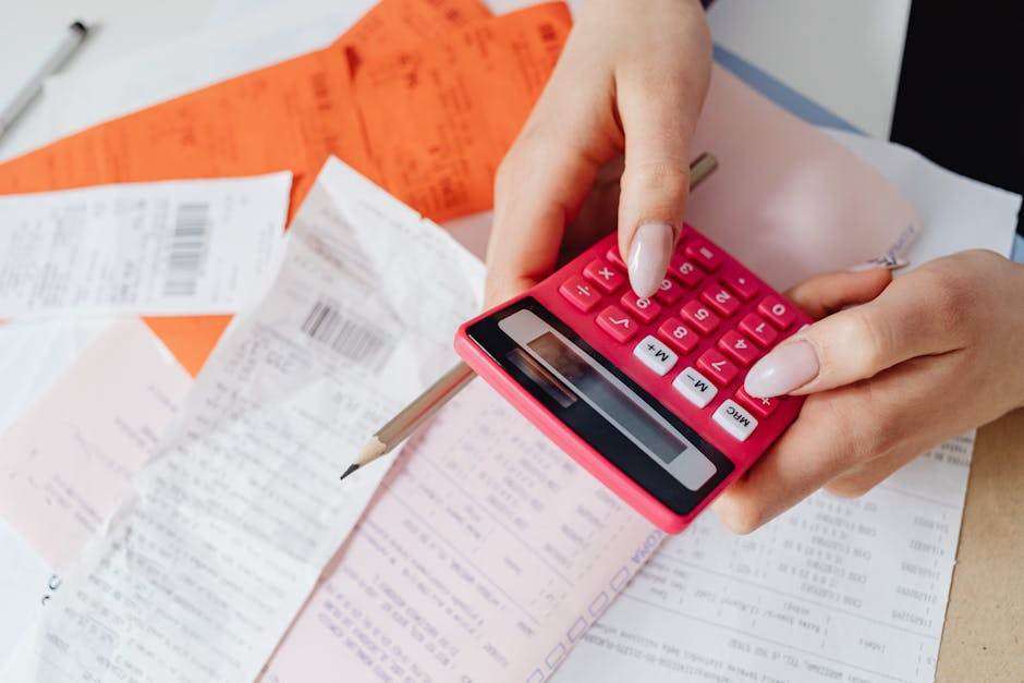 Close-up of a savings account passbook and calculator on a desk