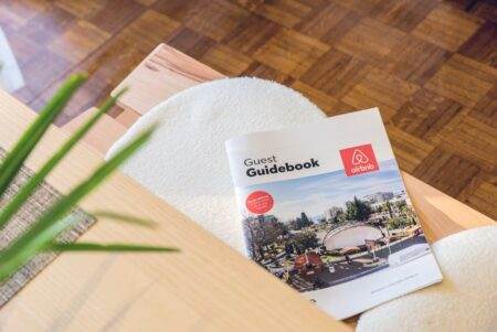 Astuces de déménagement 2026 : l’article que les pros appliquent vraiment Airbnb Guest Guidebook on a modern table in Kavala, Greece home.
