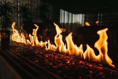 L’astuce du liquide vaisselle pour le bois de chauffage : efficace, ou gadget de plus ? Close-up of vibrant flames dancing over embers in an indoor fireplace setting.