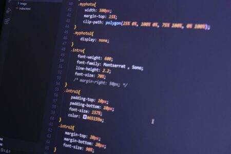 JeChange : le comparateur qui traque vos factures d’énergie, télécoms et assurances Focused shot of HTML and CSS code on a monitor for web development.