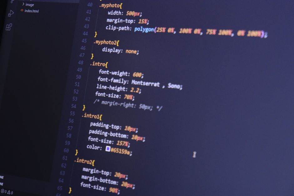 JeChange : le comparateur qui traque vos factures d’énergie, télécoms et assurances Focused shot of HTML and CSS code on a monitor for web development.