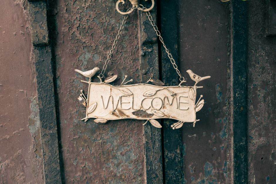 Front door with a no soliciting sign and a person refusing entry