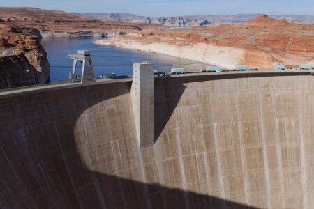 Stunning view of Glen Canyon Dam with Colorado River and red rock formations.