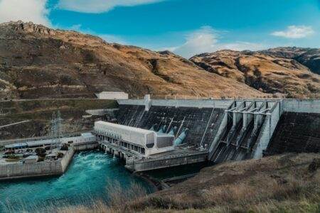 Alerte EJP : pourquoi votre voyant peut vous ruiner… et comment réagir en urgence Powerful hydroelectric dam nestled in a rugged mountain landscape with clear blue waters.