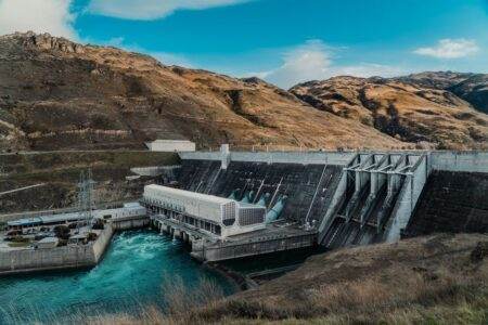 Classement 2025 des fournisseurs d’électricité les moins chers : ce que les comparateurs ne vous disent pas Powerful hydroelectric dam nestled in a rugged mountain landscape with clear blue waters.