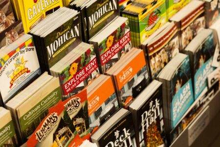 Guide concret des différentes étapes d’un déménagement réussi Colorful collection of travel brochures on display at a bookstore.