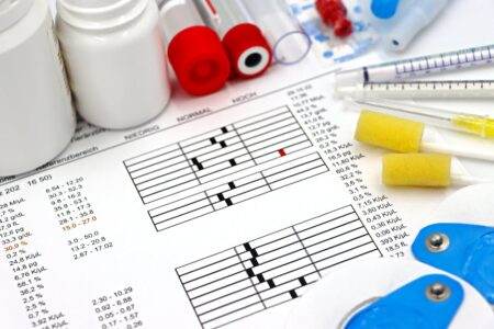 Tests dentaires : quels examens, pour qui, à quel prix en 2026 Arrangement of medical equipment, lab tests, and health data on a clinical table.