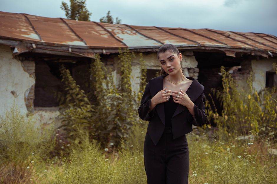 Facture de gaz : la baisse d’avril cache un choc de +20 % en mai A stylish woman poses elegantly in front of a rustic, abandoned building, showcasing modern fashion.