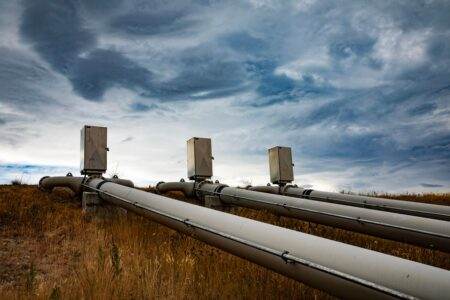 Gaz vert et agriculteurs français : en mars 2026, qui finance vraiment le biogaz local ? A series of large industrial pipes under a dramatic cloudy sky in New Zealand.