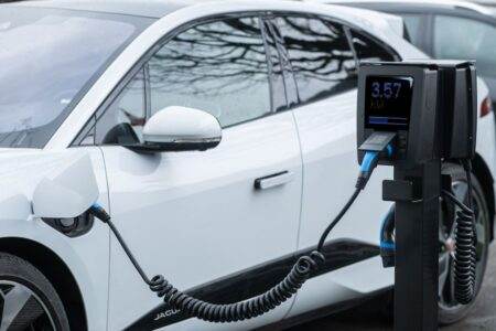 Close-up of an electric vehicle charging at a station, showcasing energy-efficient technology.