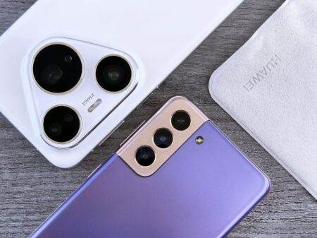 Électricité “gratuite” ou “à volonté” : que valent vraiment les offres Engie et Octopus Energy ? Close-up of two smartphones with camera focus on a textured wooden surface.
