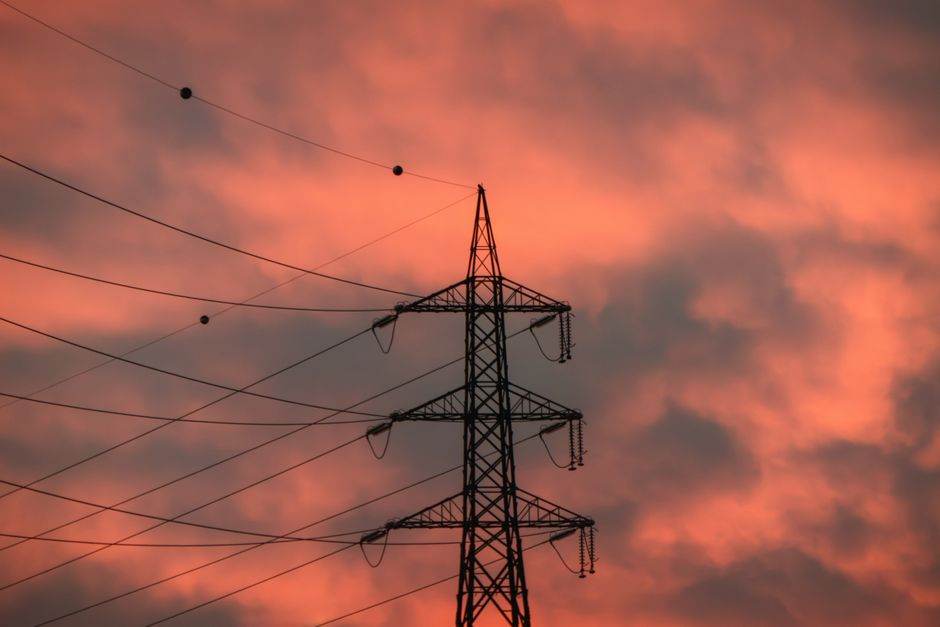 High-voltage power lines and electrical grid at dusk