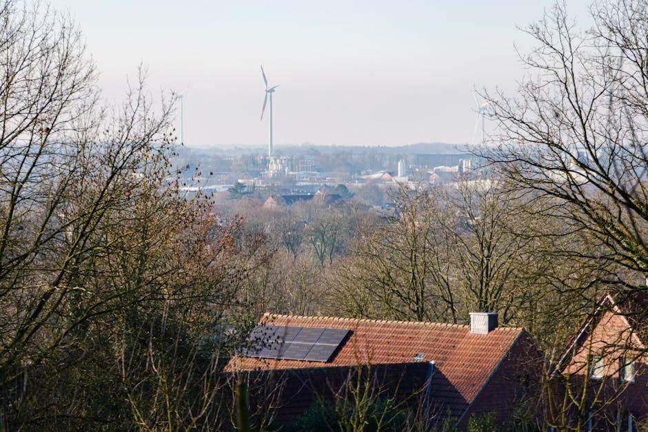 Facture d’électricité démentielle : quand un fournisseur vous facture la consommation d’un village View of Coesfeld with solar panels on rooftops and wind turbines in the distance.