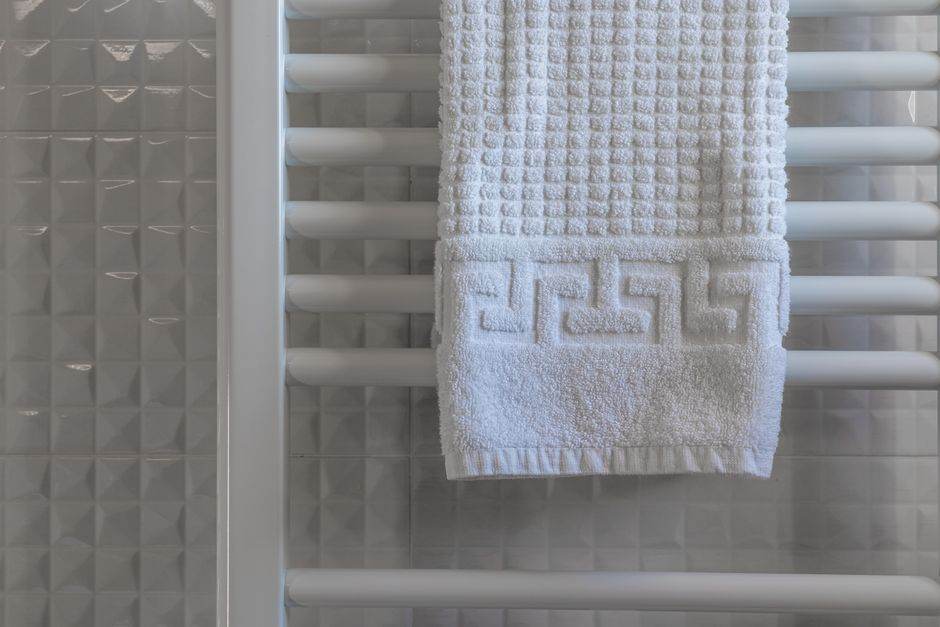 Electric towel radiator in a bright bathroom