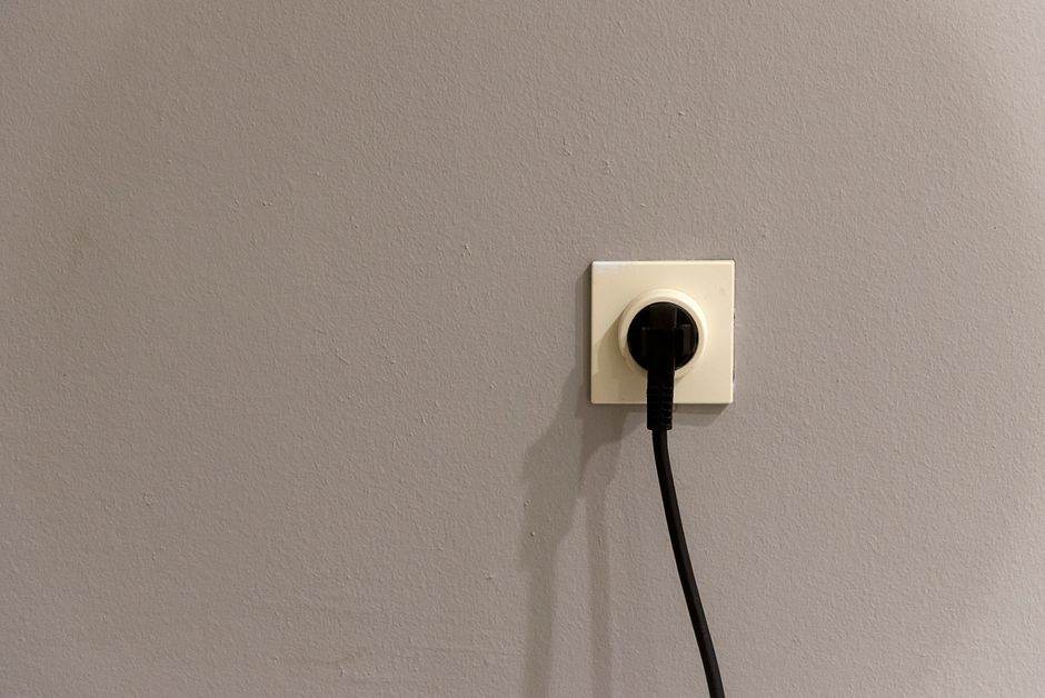 Person adjusting home appliances to save electricity during peak hours
