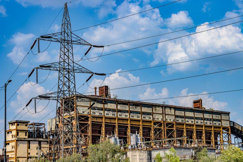 Heures creuses : l’offre la moins chère de France en mars 2026 change vraiment la donne ? Photograph of an abandoned industrial building with a power line tower against a blue sky.