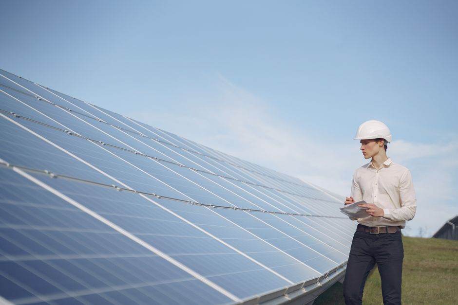 Classement 2025 des fournisseurs d’énergie les plus saisis par le Médiateur : qui traite vraiment bien ses clients ? Young serious male engineer in formal outfit and helmet reporting while inspecting solar panel field
