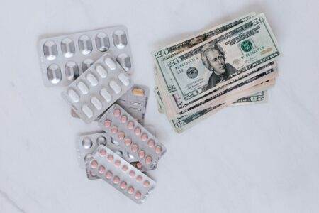 Prix de l’électricité hiver 2025-2026 : les offres qui valent vraiment le coup From above of silver blister full of drug near big pile of dollar to spend on medication