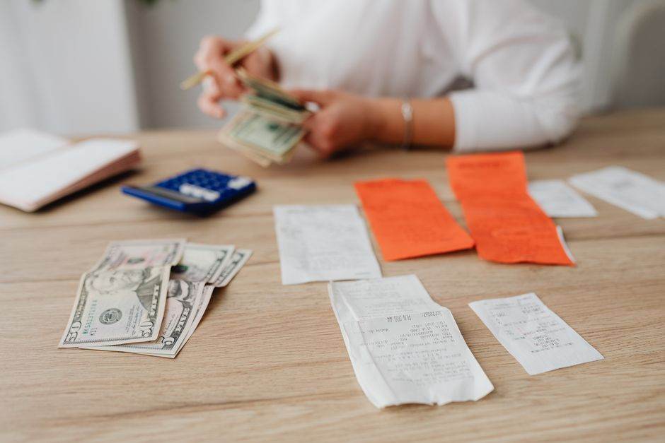 Person checking household bills and comparing energy costs at a table