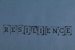 RESILIENCE printed in vintage style on a textured blue background paper.