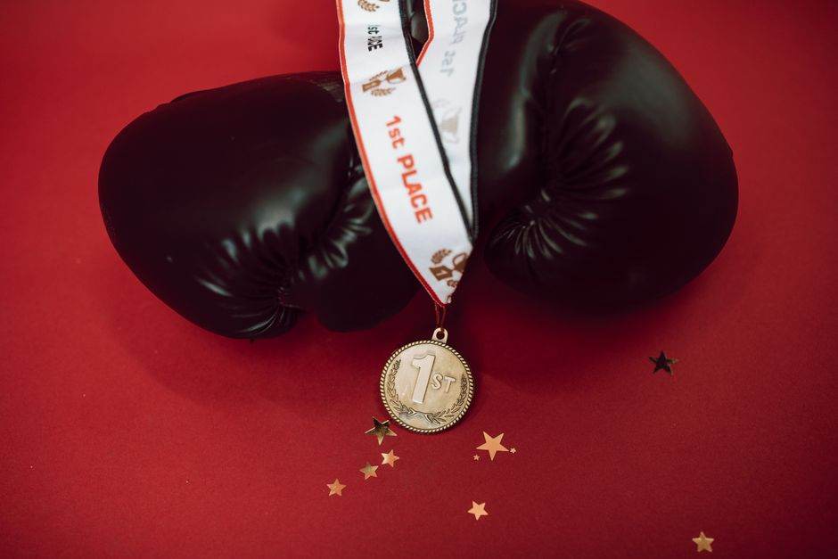 Quel contrat d’électricité pour affronter une vague de froid sans exploser sa facture ? Black boxing gloves with a gold medal on a red background, symbolizing victory and success.