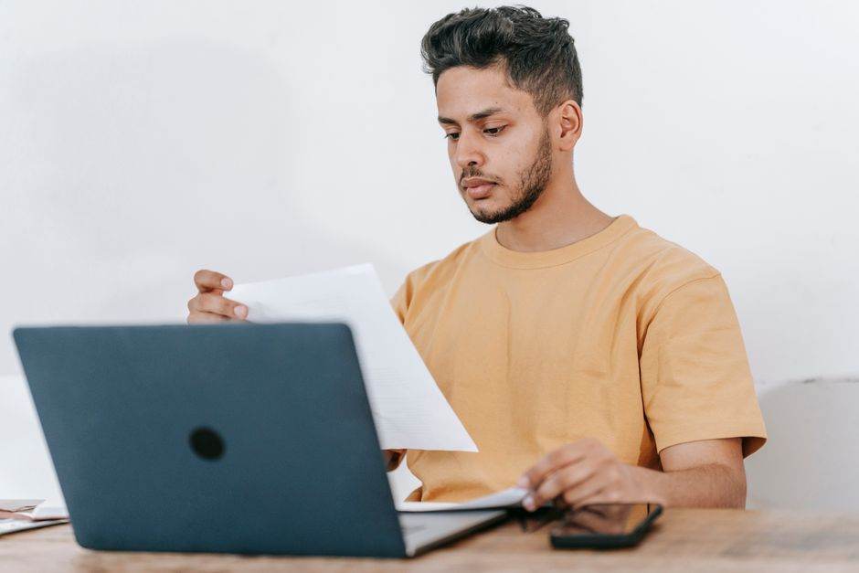 Person reviewing electricity contract with green energy comparison on laptop