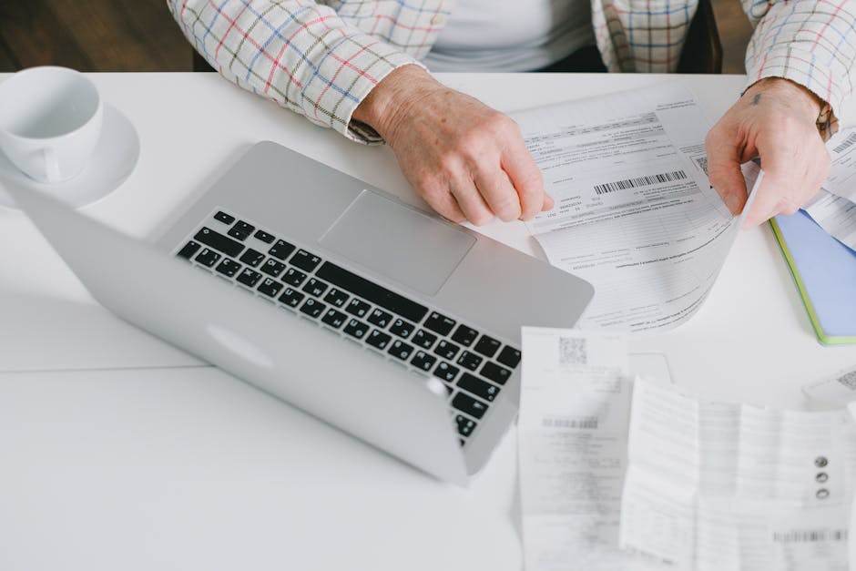Personne consultant une facture d'électricité sur ordinateur