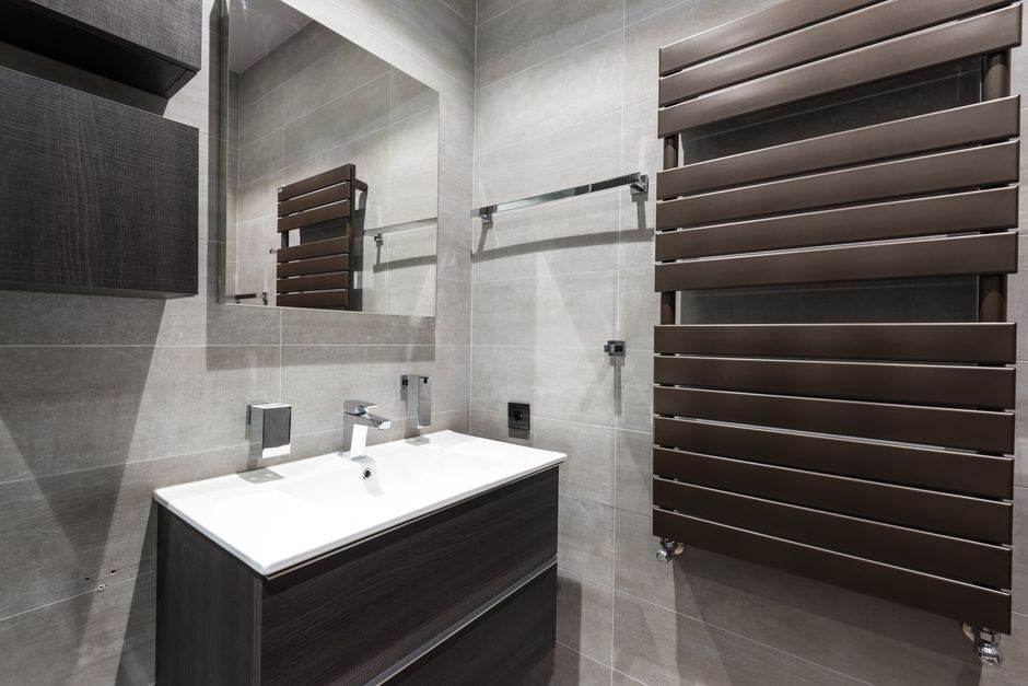 Modern bathroom with heated towel radiator on the wall