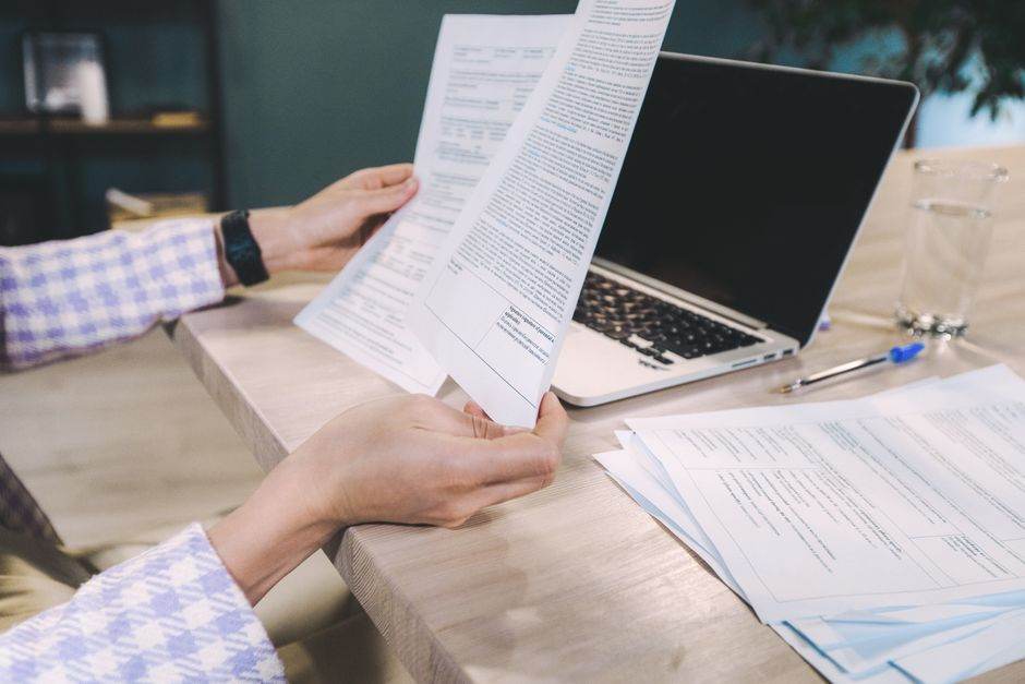 Person reviewing utility bills and comparing energy contracts